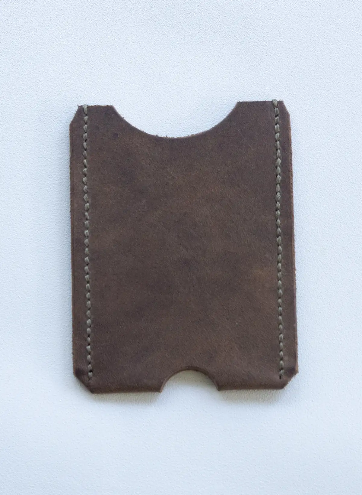 A slim crazy horse leather card holder wallet displayed on a neutral surface.